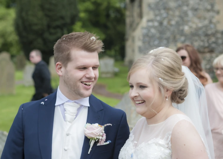 a bride and groom are smiling and having their picture taken outside the church