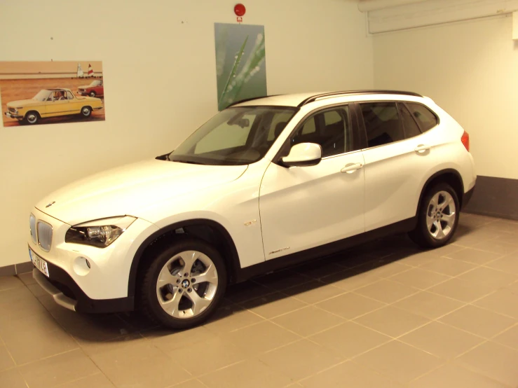 a white suv is on display in the garage