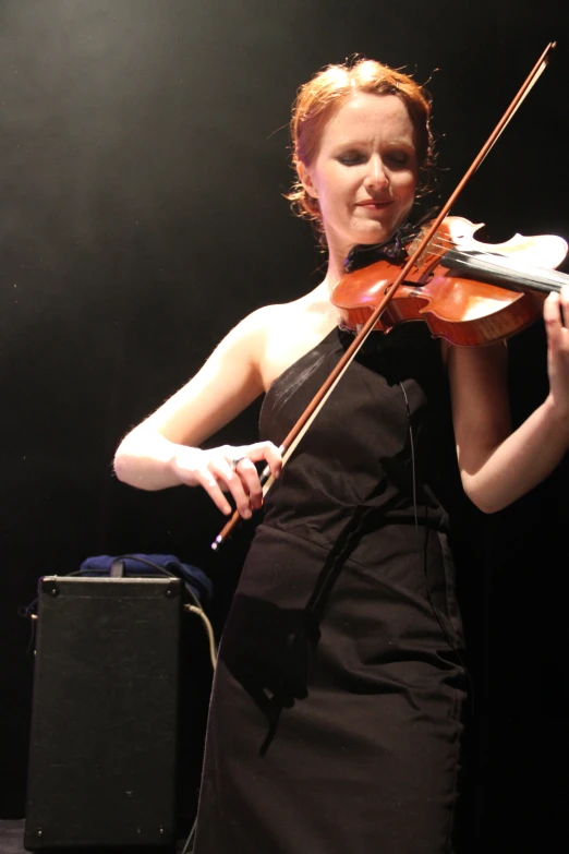 woman in a black dress playing a violin