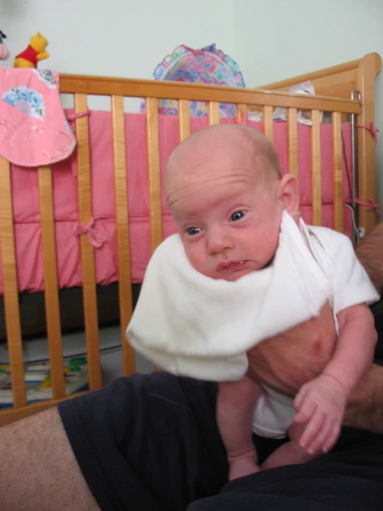 a baby is being held in front of a crib