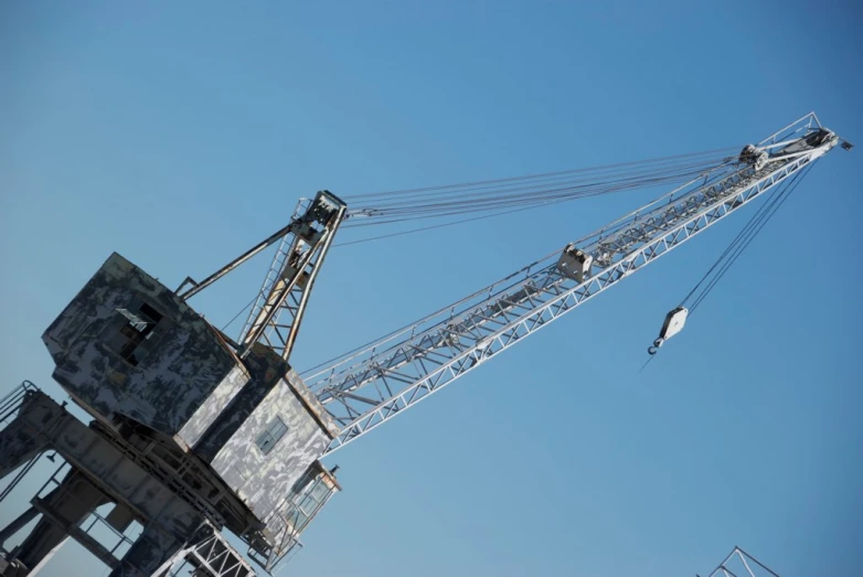 a tall crane standing above a building and another large structure