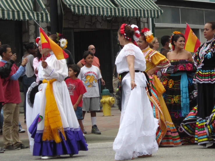 people dressed in mexican clothing walking on a street