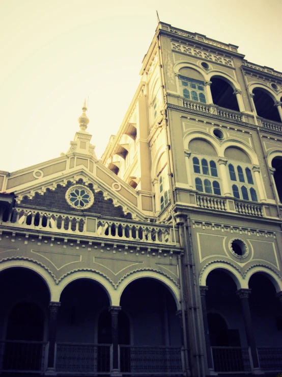 a large building that has pillars with an open doorway and a clock on the front