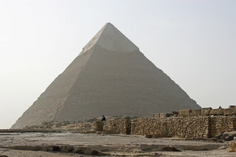 a giraffe standing in front of a large pyramid