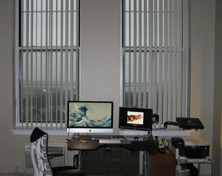 a computer desk with two monitors and various electronics