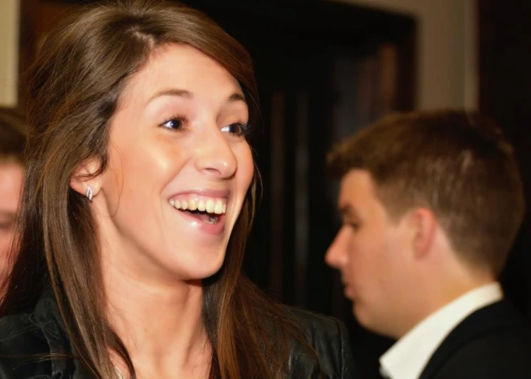 a beautiful young woman smiling at someone near her