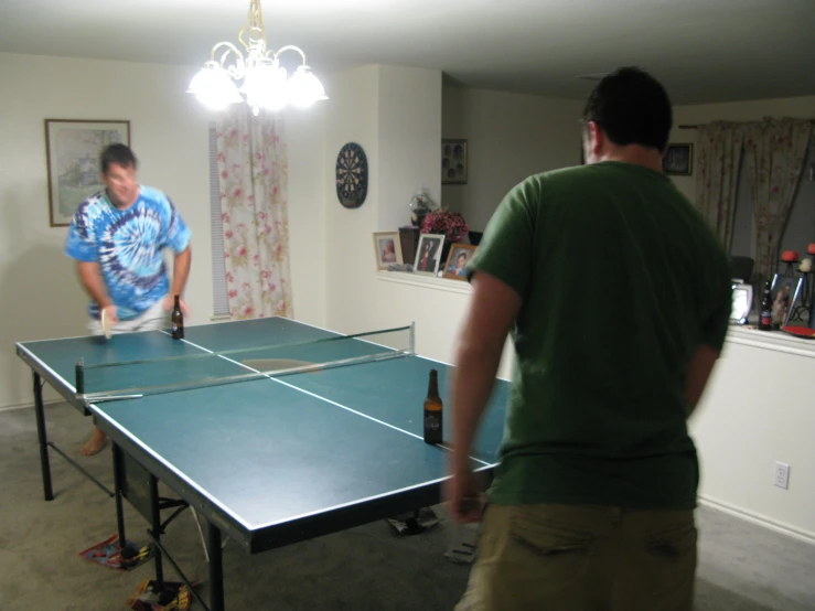 two men playing table tennis in the middle of a room
