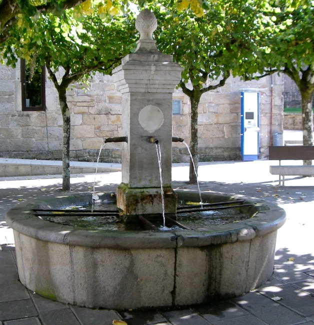 a small fountain with four spouts and one of them in the center