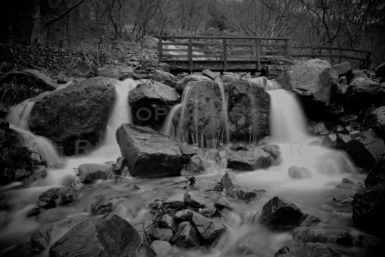 a river flowing past a wooden bridge