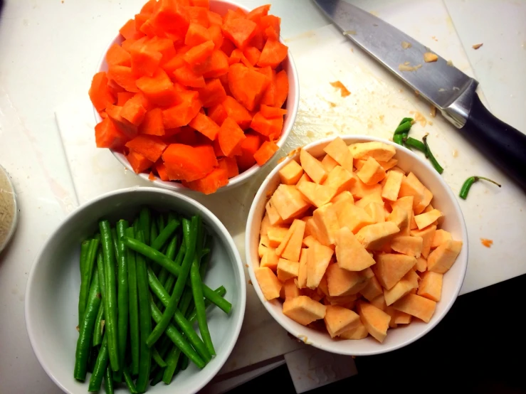 carrots, green beans, and cheese in white bowls