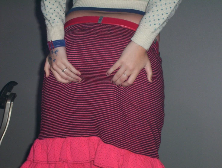 a girl with long sleeves wearing a red skirt