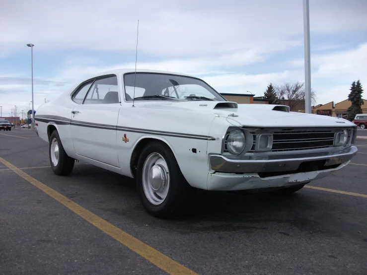 an old white car is parked in a lot