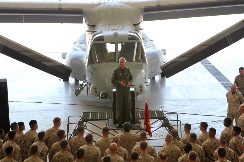 several military men stand at steps to an aircraft