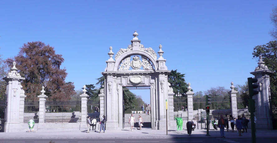 people are standing outside near some ornate arches