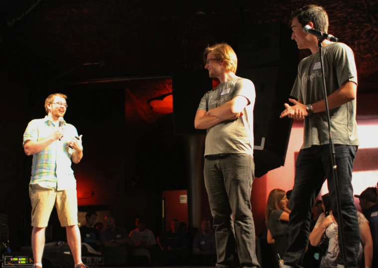 a group of people standing in front of microphones