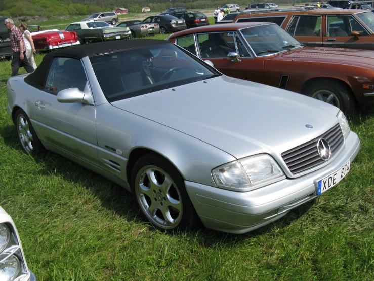 several cars sitting next to each other on a field