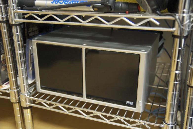 a silver shelf with a metal unit and hairdryer