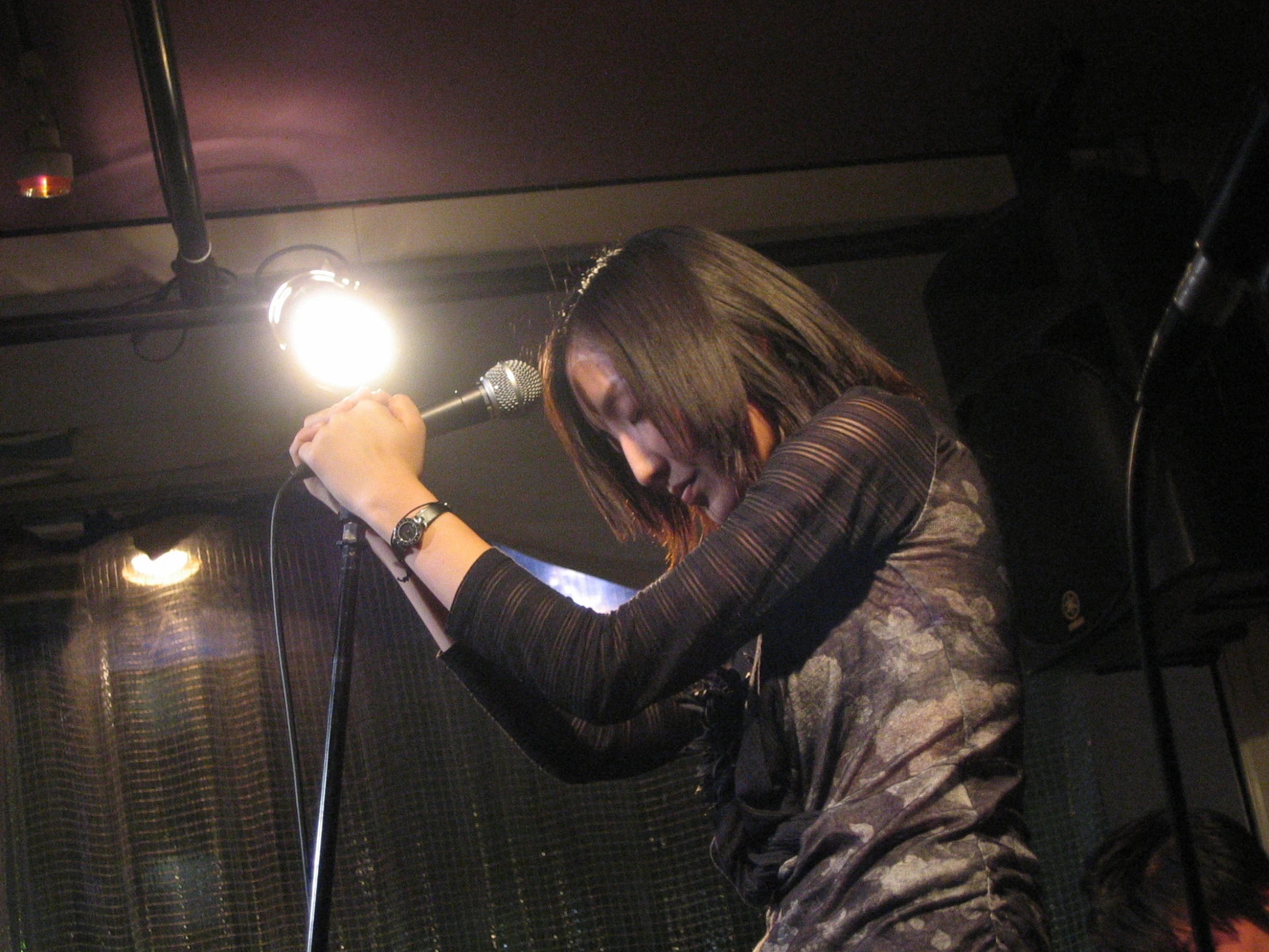 a woman singing on stage with a microphone