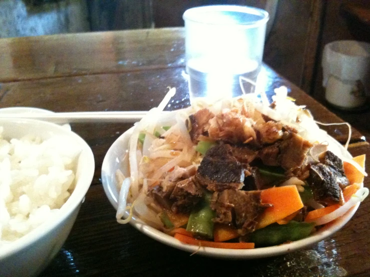 a bowl of meat and rice on a table