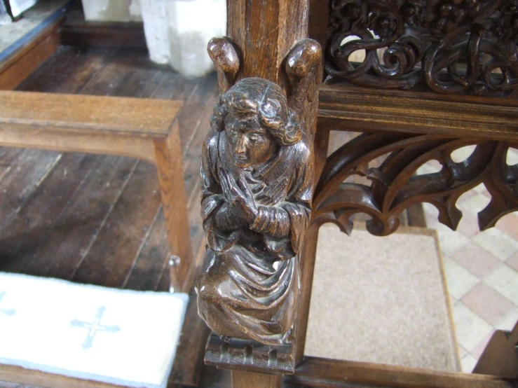 a religious statue on a wooden stand with marble floor tiles