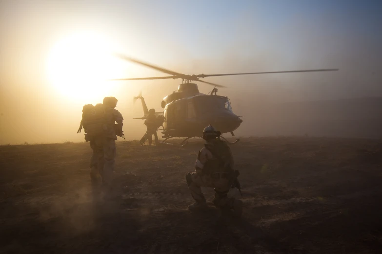 the army men are in front of a helicopter on a dirt field