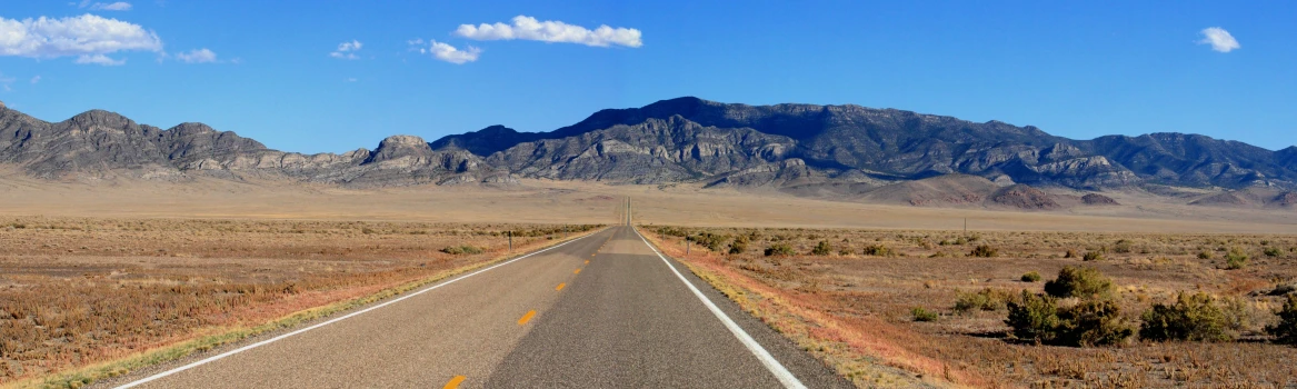 an empty open highway in the middle of desert