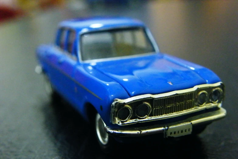 a toy model of a blue classic car on display
