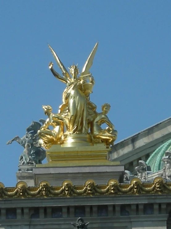 a golden statue sitting on top of a building