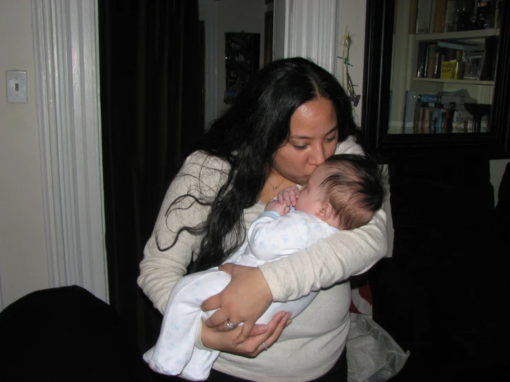 a mother holding her baby in a room