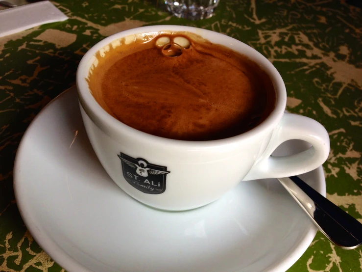 a cup of coffee and a spoon are sitting on the saucer