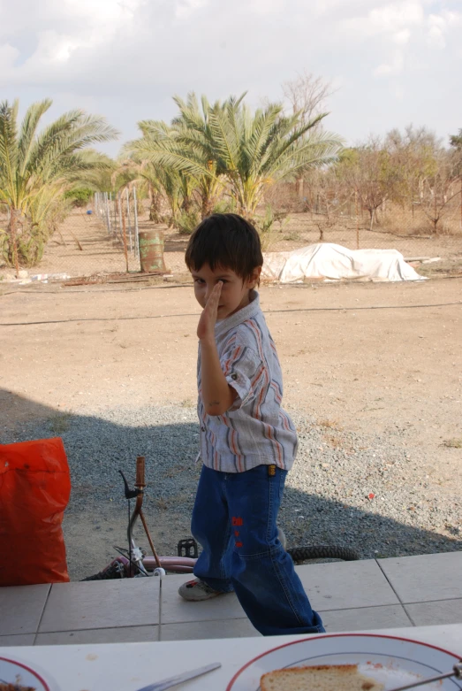 a boy standing on top of a street next to a plate of food