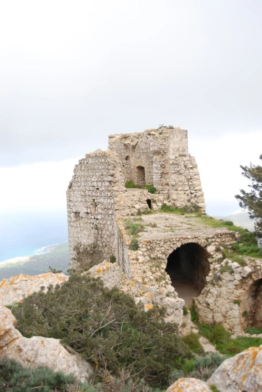 a stone castle on top of a rocky mountain