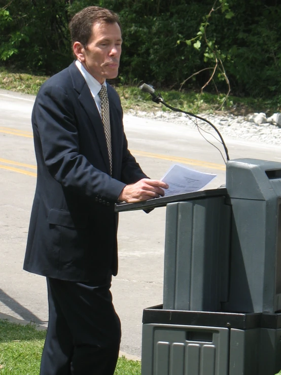 a man standing at a podium while giving a speech