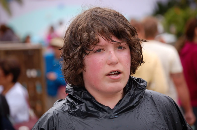 a boy that is outside wearing a wet coat