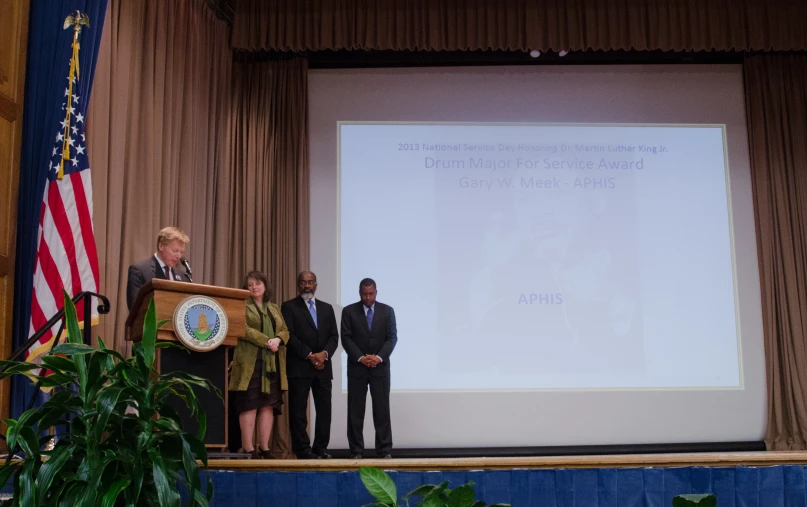 two women and a man giving a speech at a podium