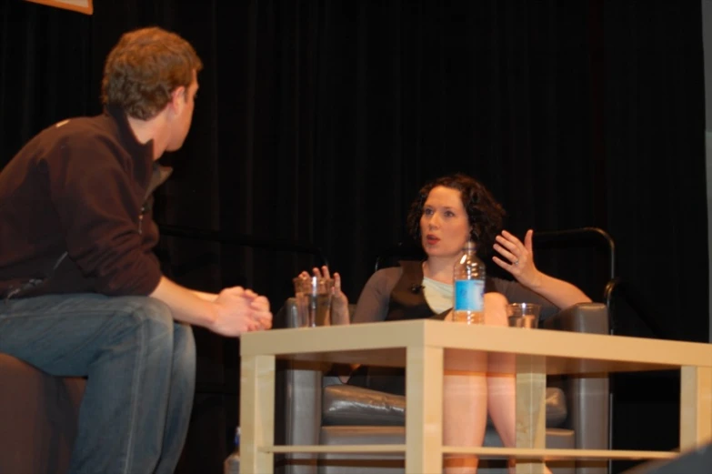 a person is talking on the stage while sitting down