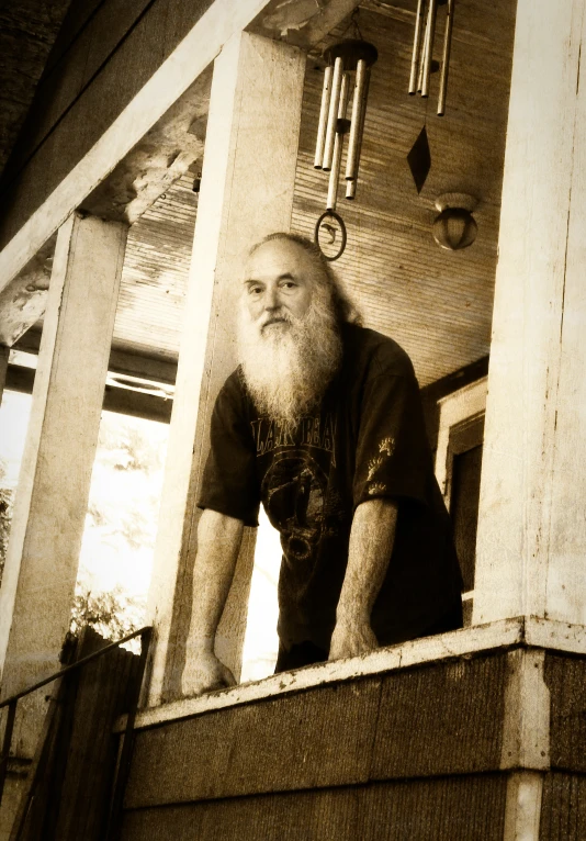 man with long white beard on outdoor balcony area