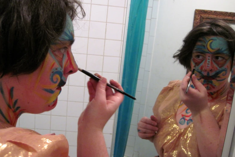 a young woman is getting her face painted