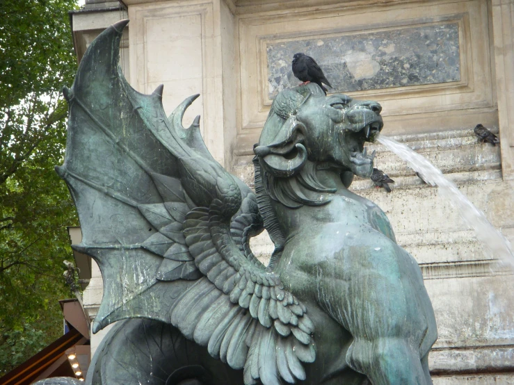 a fountain that has a large dragon statue next to it