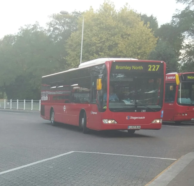 a large red bus driving down a road