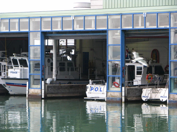 two boats are parked in the water outside of a building