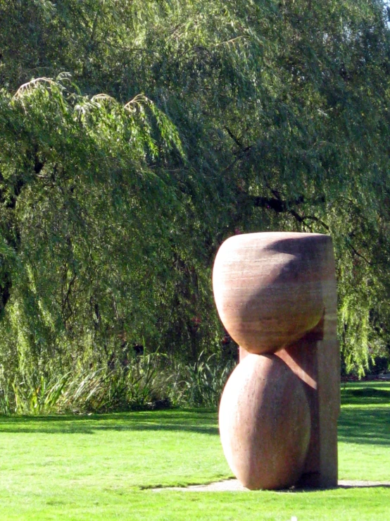a stone sculpture that is standing in the grass