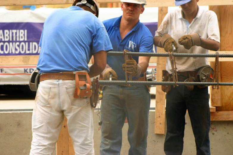 construction workers with safety gear checking a gate