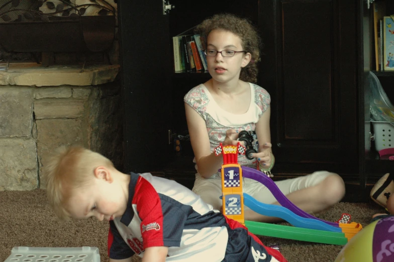 two small children playing with toy blocks and toys