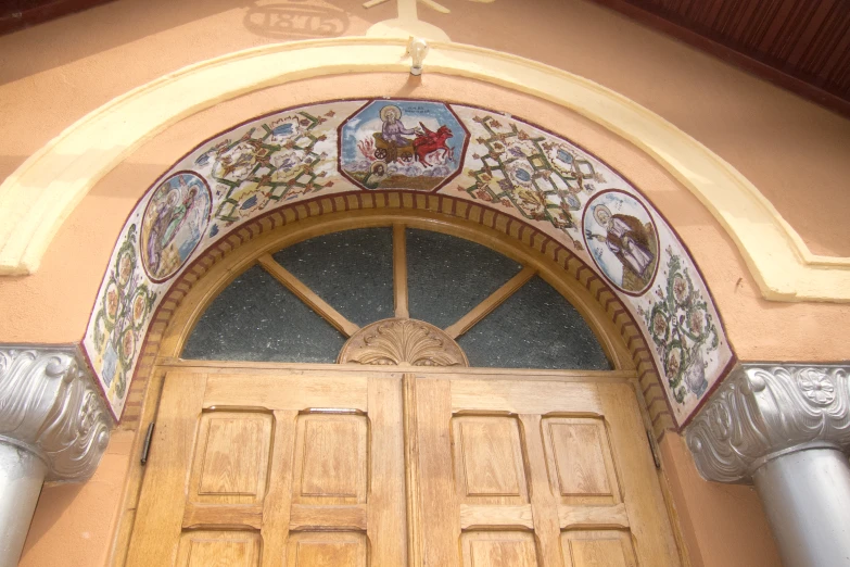 a large yellow wooden door has ornate designs and crosses