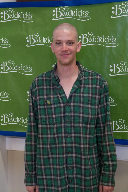 a bald man is standing in front of a sign