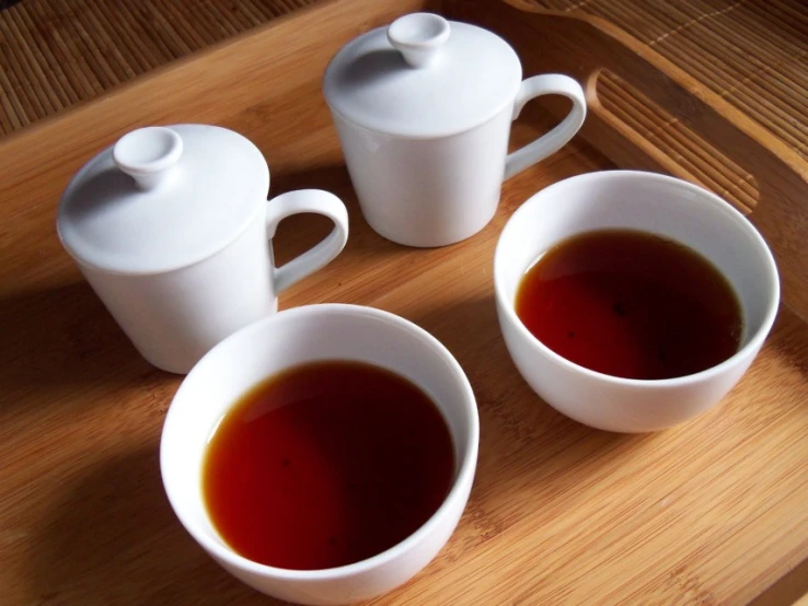 three cups of tea are sitting on a table