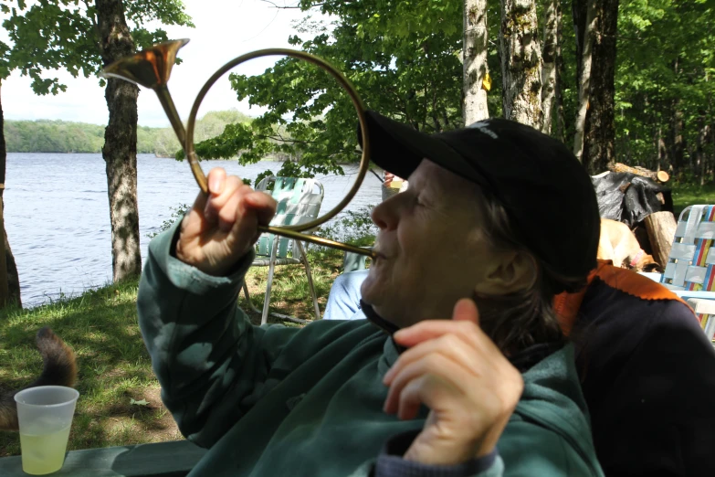 a person is holding up a ring next to trees