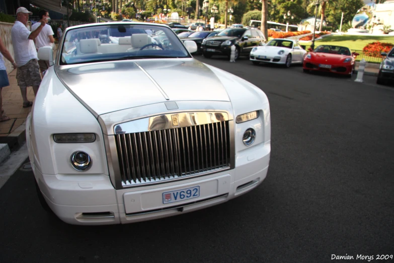 the front of a white rolls royce sports car parked on a street