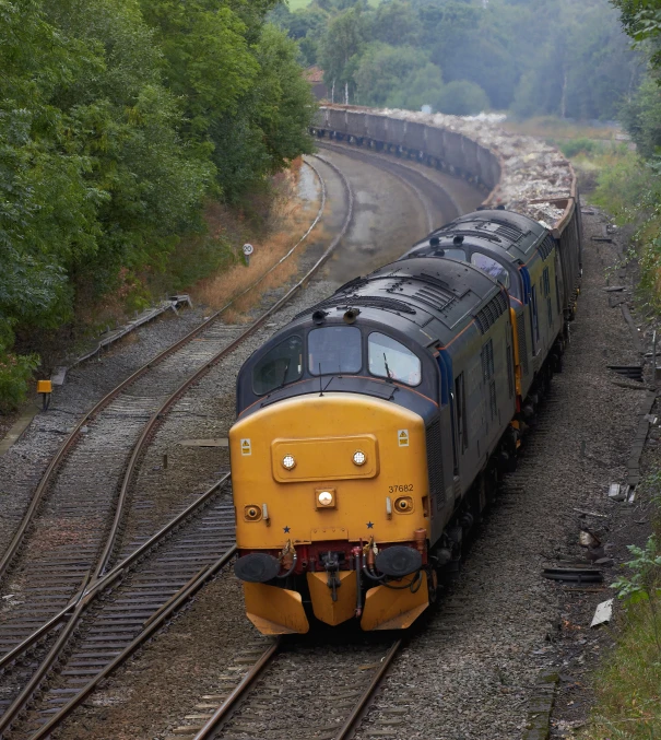 a yellow and black train traveling on a track